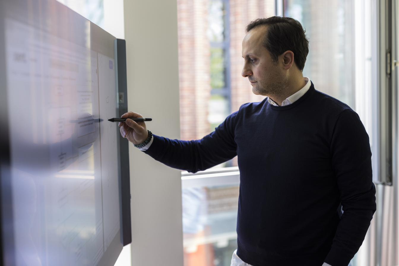 Xient-Mitarbeiter arbeitet am digitalen Whiteboard im Büro