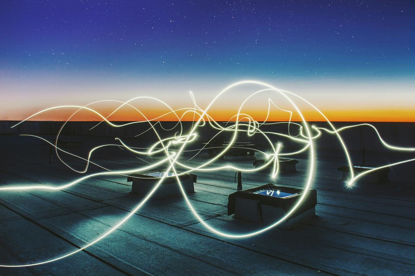 Lichtspuren über einer Energielandschaft in der Dämmerung