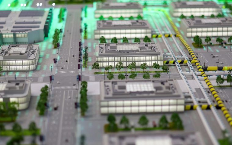 3D-Modell eines Stadtquartiers mit Gebäuden und grün leuchtenden Energiewegen.